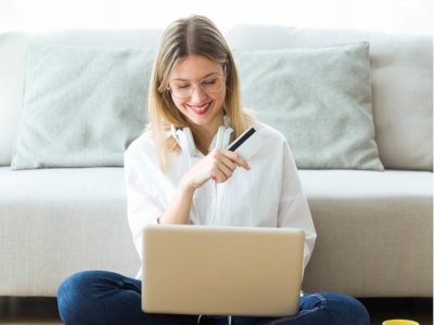 Lady sitting on the floor looking at her laptop at her investments